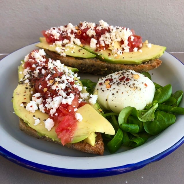 Tostadas de aguacate, feta y tomate con huevo poche
