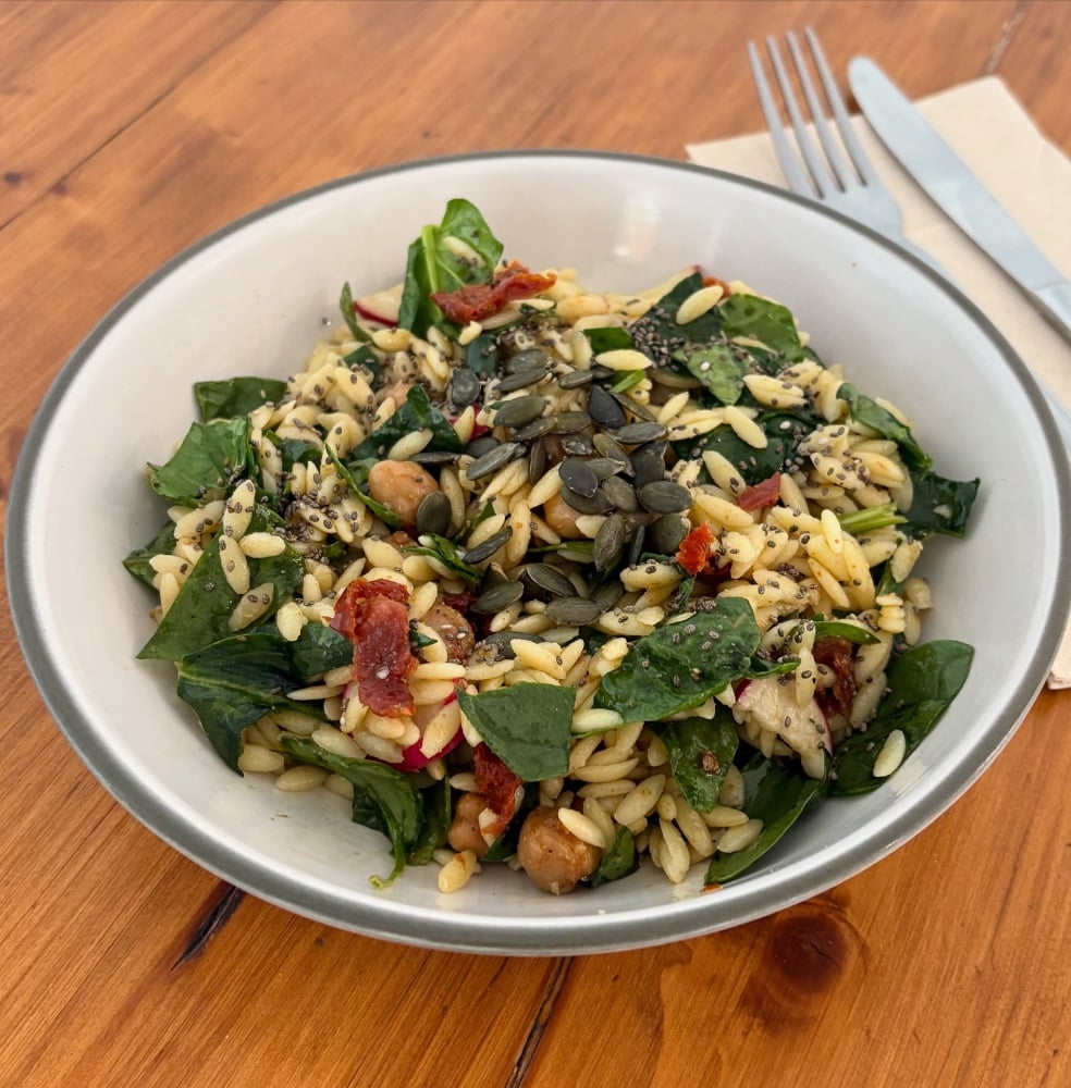 Ensalada de pasta orzo, garbanzos asados, tomates secos y espinacas. 